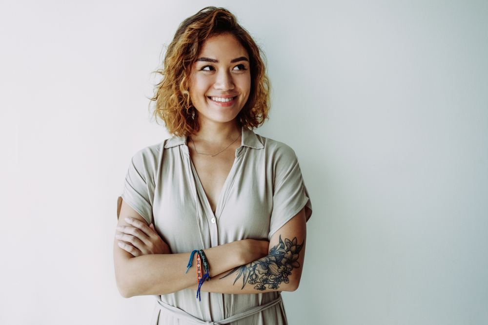 asian woman with tattoo design on arm