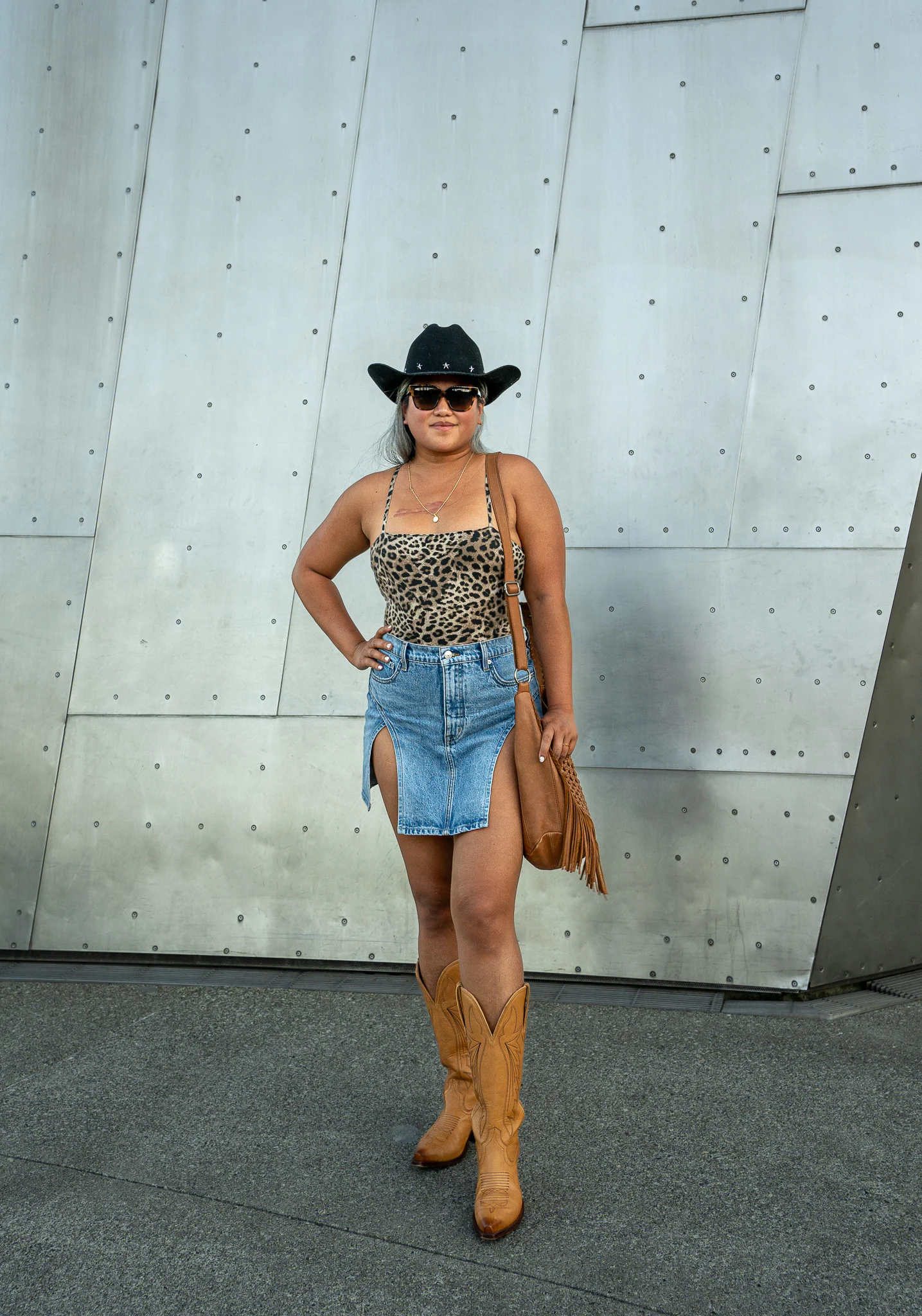 Cowgirl outfit idea Augustine dolly hat leopard bodysuit GRLFRND Jasmine denim skirt The Sak Filmore Crossbody Tecovas Kasey Western Boot Mohala Sunglasses